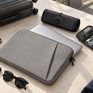 Padded laptop sleeve and compact tech organizers arranged for everyday travel carry.