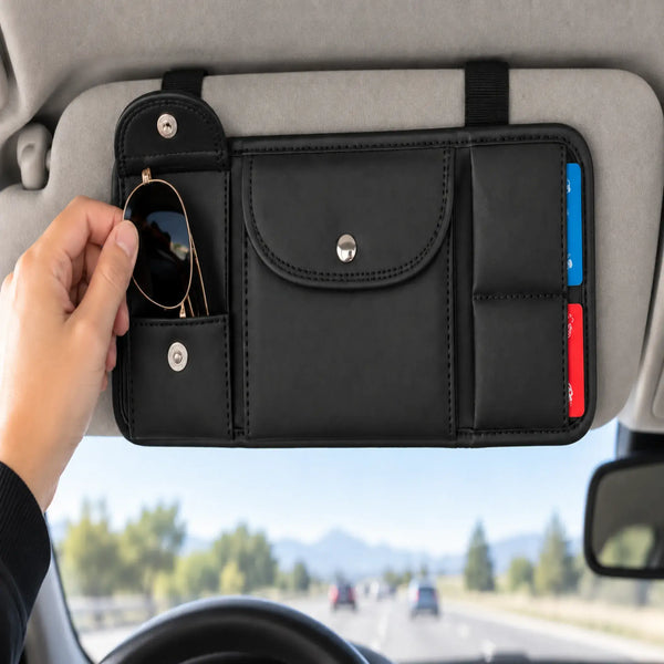 Hand removing sunglasses from open pouch of black organizer mounted on a vehicle sun visor